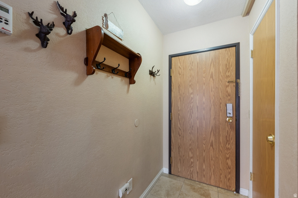 Entryway featuring tile patterned floors and a textured wall