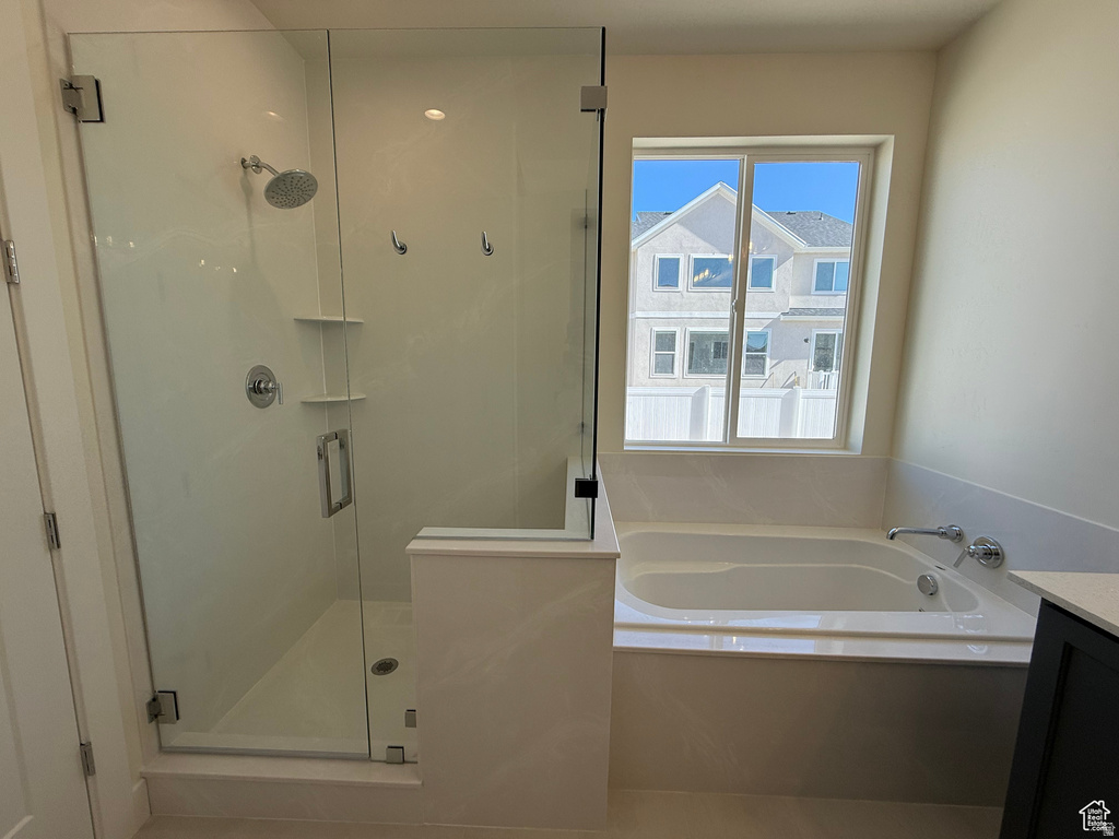 Full bath featuring vanity, a garden tub, a stall shower, and tile patterned flooring
