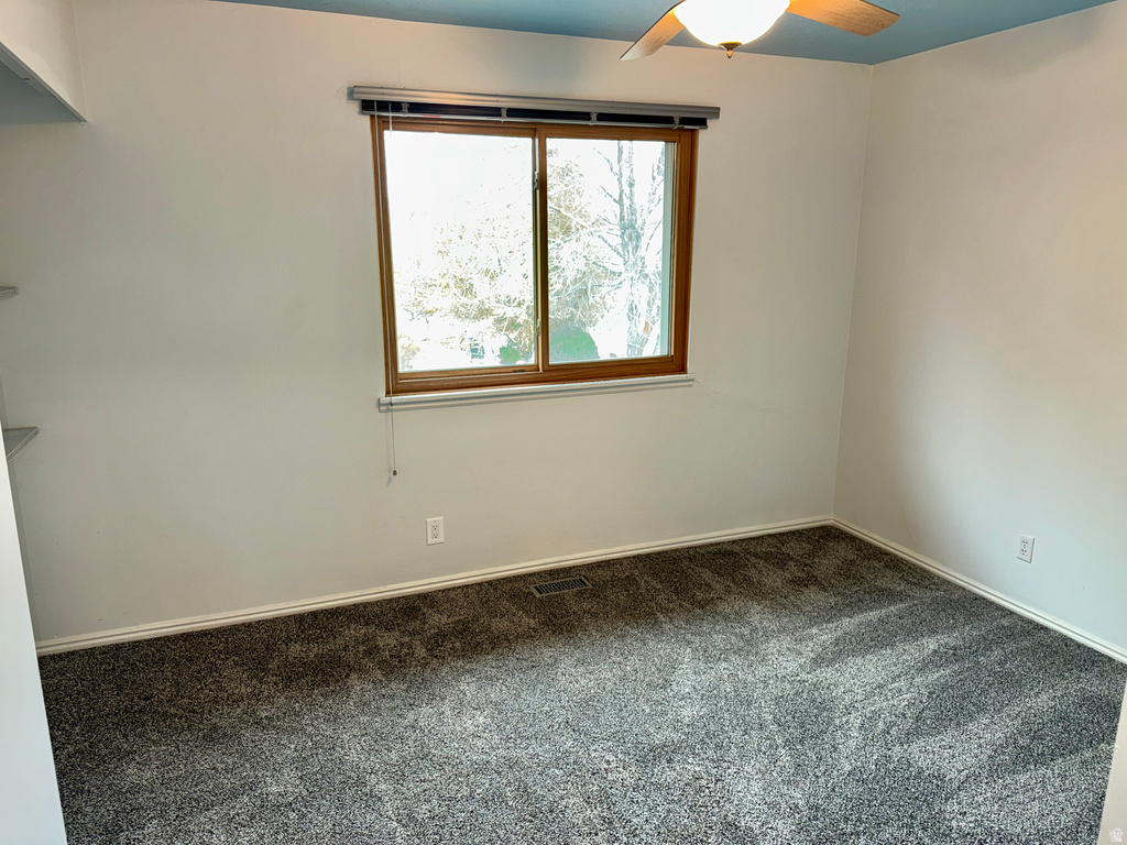 Empty room featuring carpet floors and ceiling fan