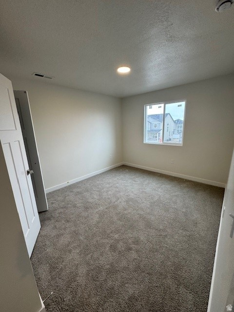 Spare room with light carpet and a textured ceiling