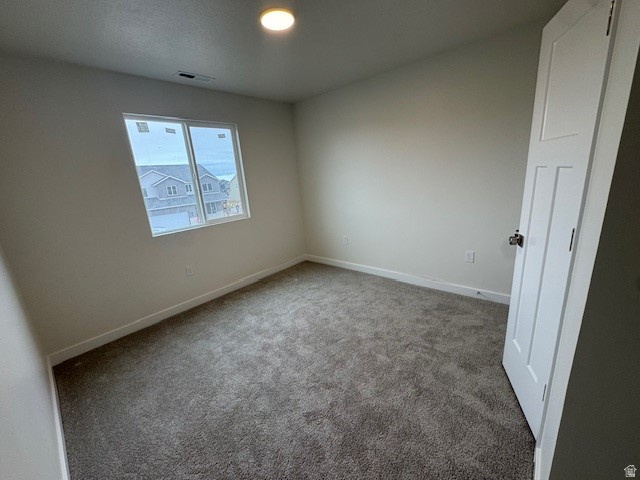 Spare room featuring carpet and baseboards