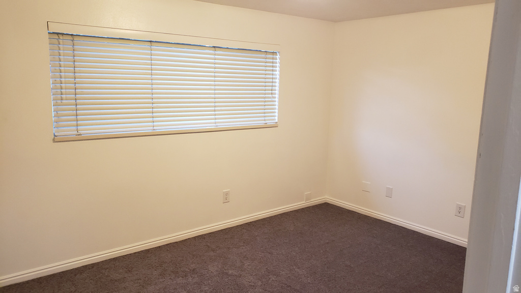 Carpeted empty room with baseboards