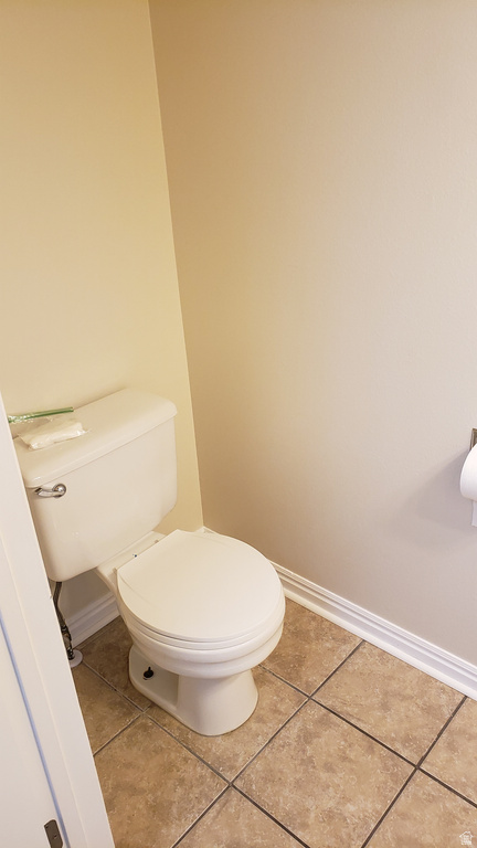 Half bathroom with baseboards and light tile patterned floors