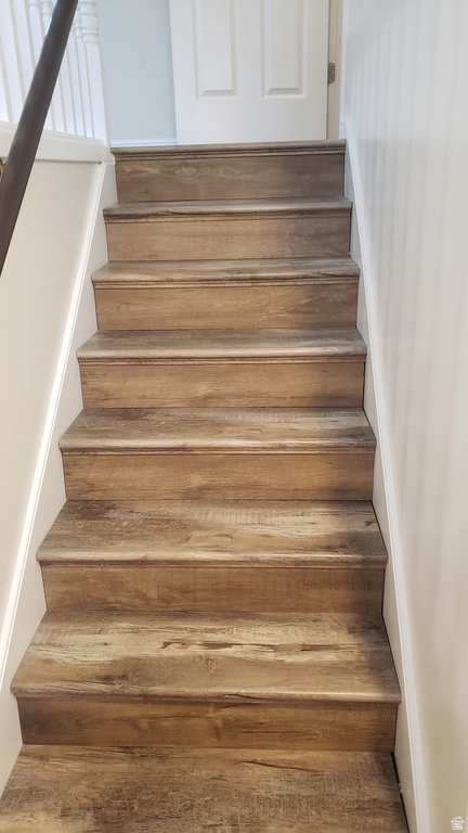 Staircase featuring hardwood / wood-style floors