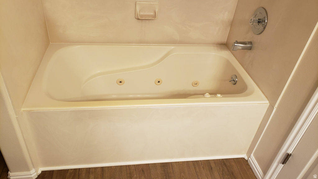 Bathroom with a whirlpool tub and dark wood-style floors