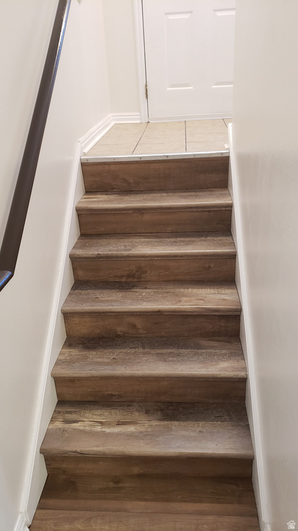 Staircase featuring wood finished floors