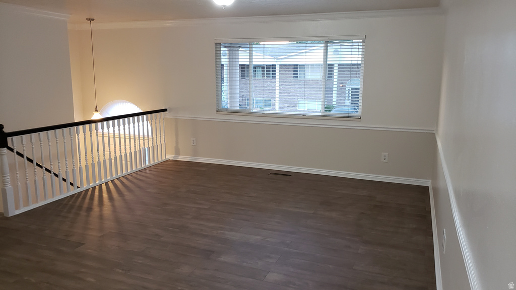 Unfurnished room with dark wood-style floors and crown molding