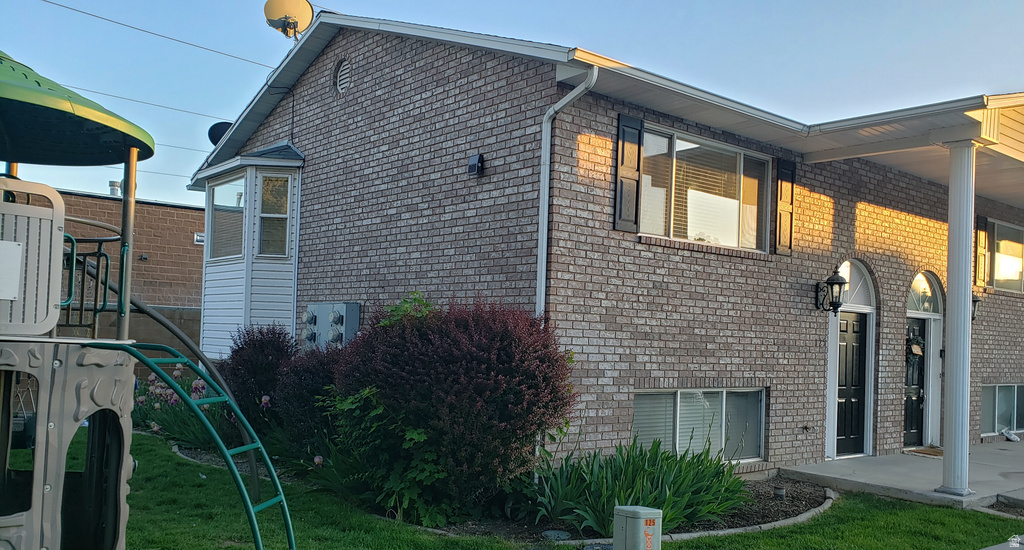 View of side of property with brick siding and a yard