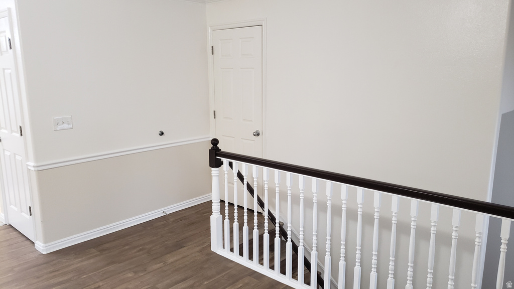 Hall featuring an upstairs landing and dark wood finished floors