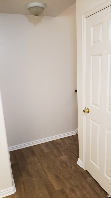 Empty room with dark wood finished floors and baseboards