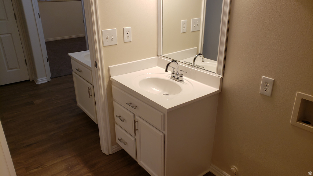 Half bathroom with vanity and dark wood finished floors