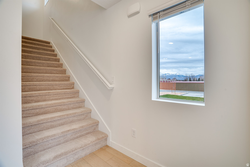Stairway with wood finished floors and a mountain view