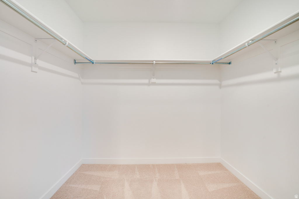 Walk in closet featuring light carpet