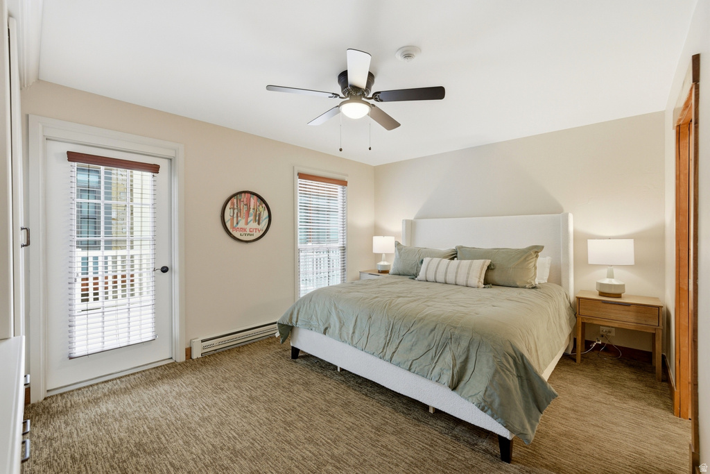Bedroom featuring carpet flooring, ceiling fan, and a built-in transom window above the door