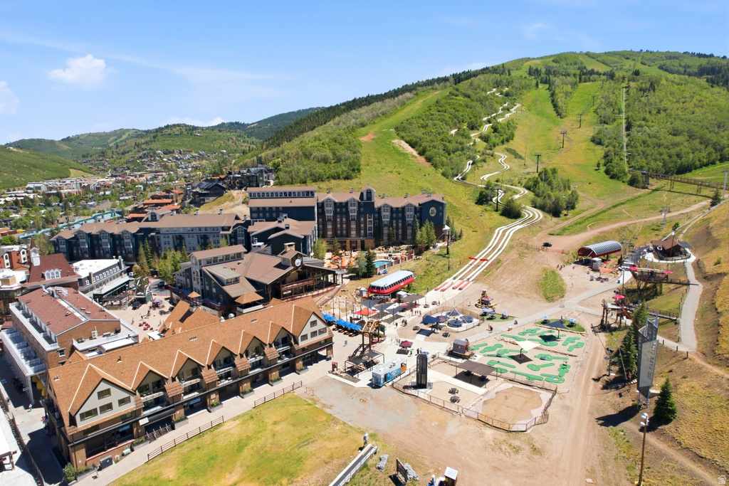 Expansive mountain resort complex featuring multiple buildings with gabled roofs, pedestrian walkways, and a miniature golf course
