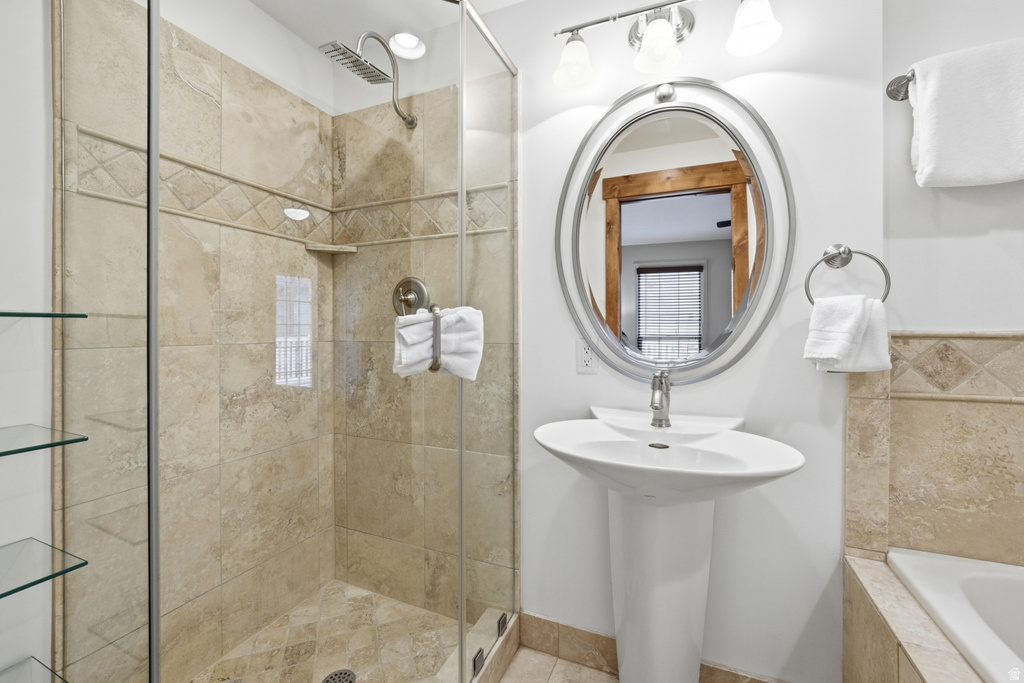 Pedestal sink with an oval mirror and brushed nickel fixtures