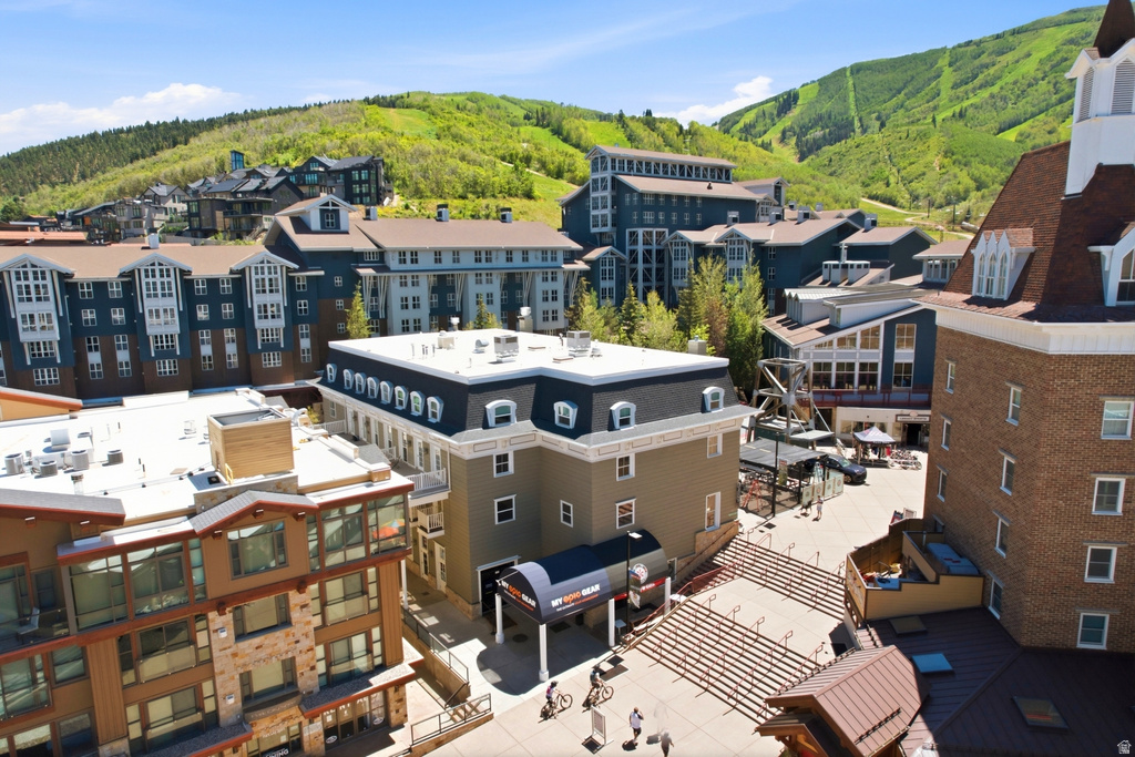 Mountain resort community featuring diverse architectural styles, visible pedestrian areas, and extensive surrounding treed hillsides