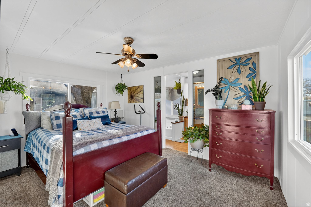 Carpeted bedroom featuring ceiling fan and connected bathroom