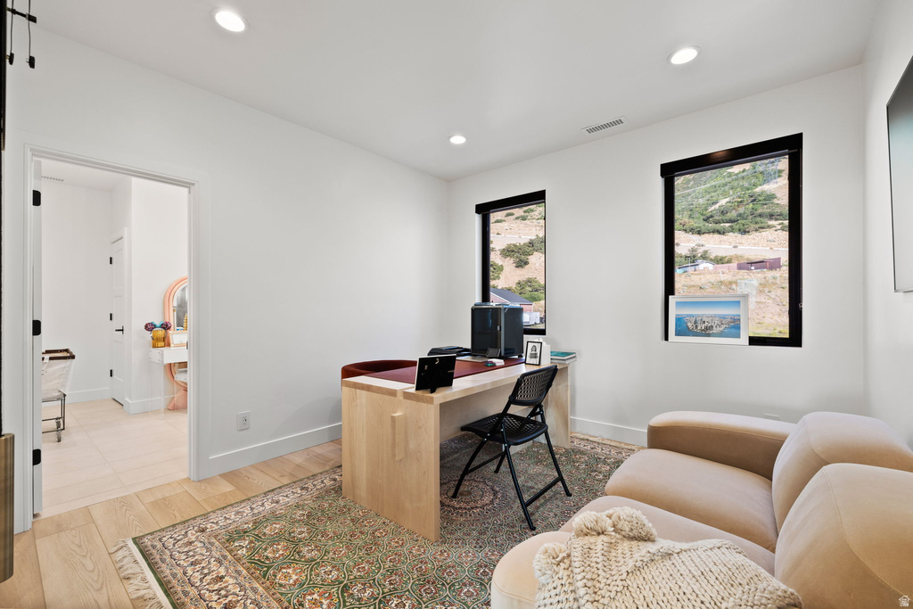 Office space with light wood finished floors and recessed lighting
