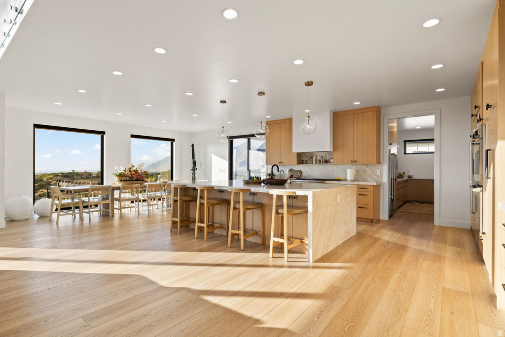 Kitchen featuring plenty of natural light, a breakfast bar area, pendant lighting, a large island, and recessed lighting