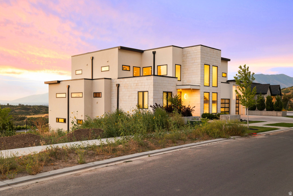 Modern home with stucco siding, a mountain view, a garage, and driveway