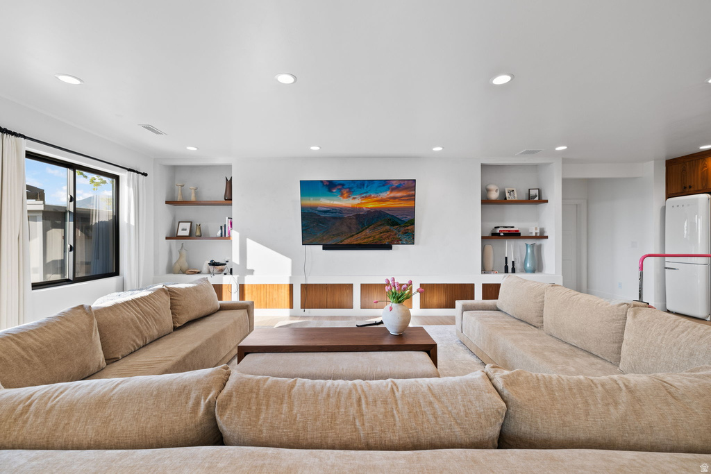 Living room featuring recessed lighting, wood finished floors, and built in shelves