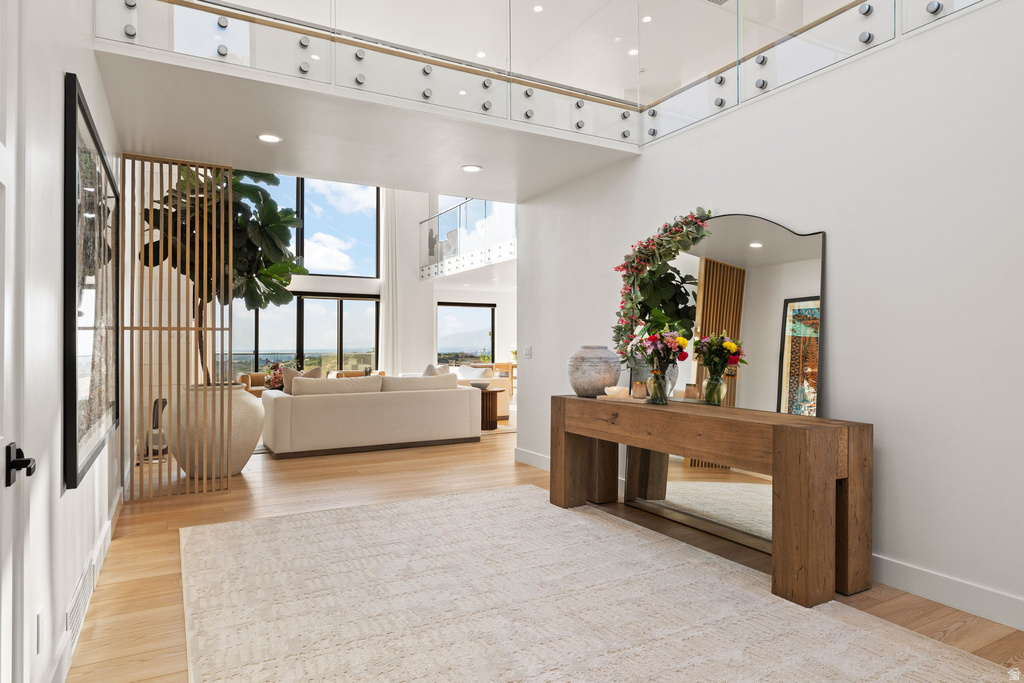 Entrance foyer with a high ceiling, light wood finished floors, and recessed lighting