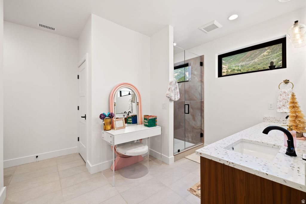 Full bath featuring double vanity, a shower stall, recessed lighting, and light tile patterned floors