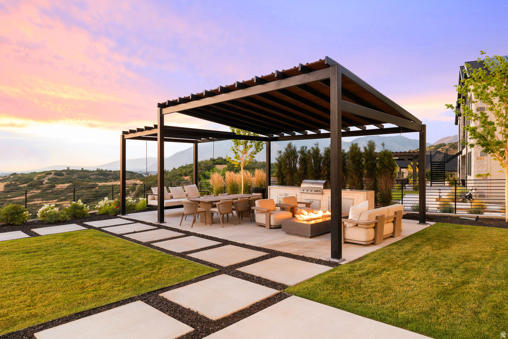 View of patio featuring an outdoor living space with a fire pit, area for grilling, a mountain view, and a pergola