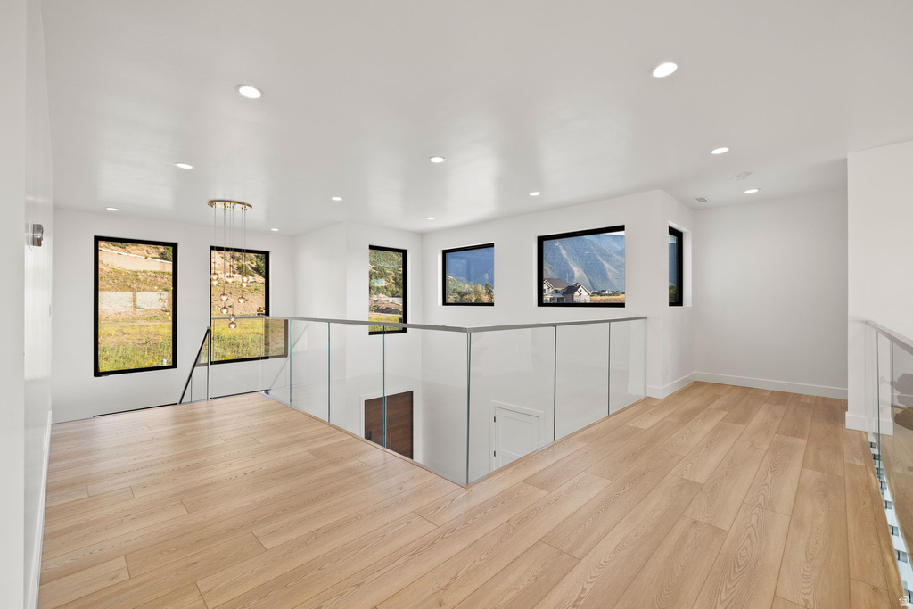 Hall with light wood finished floors and recessed lighting