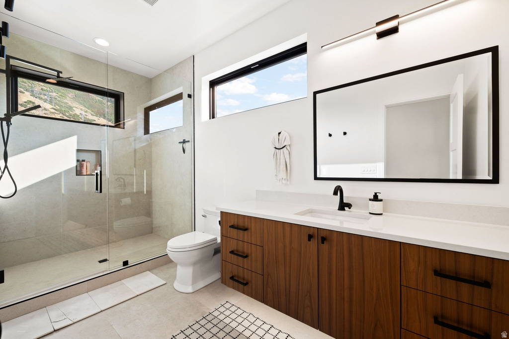 Bathroom featuring a stall shower, vanity, light tile patterned floors, and recessed lighting