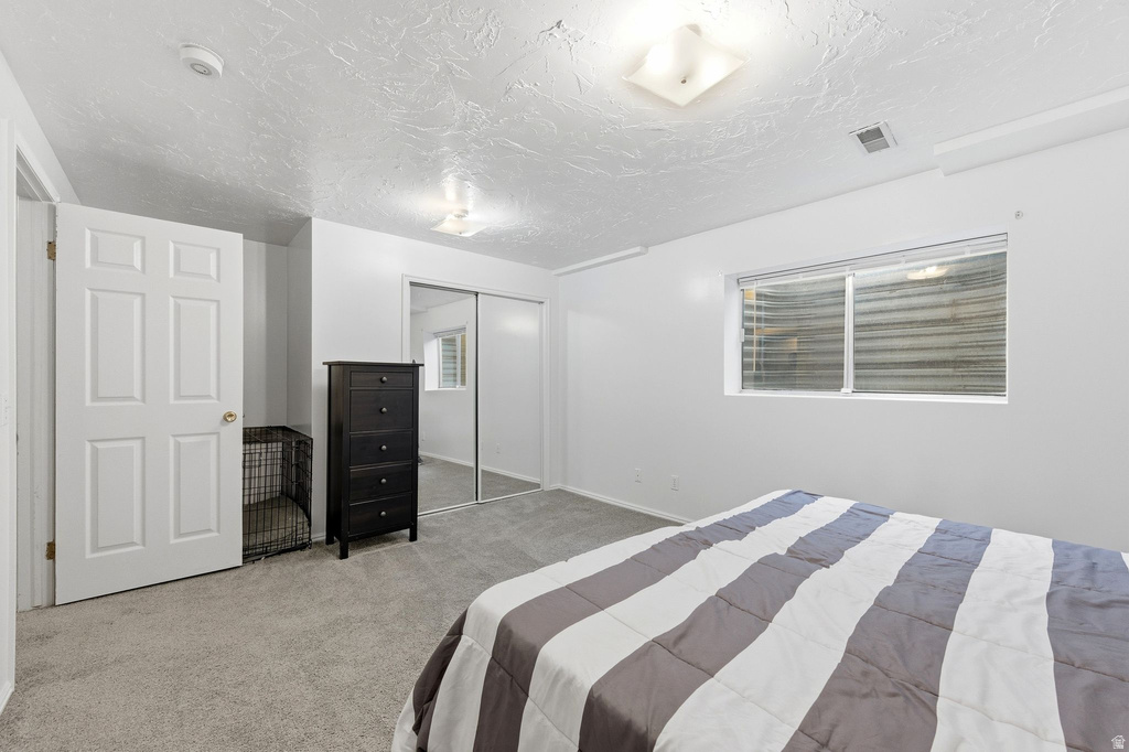 Bedroom featuring a closet, carpet floors, and a textured ceiling