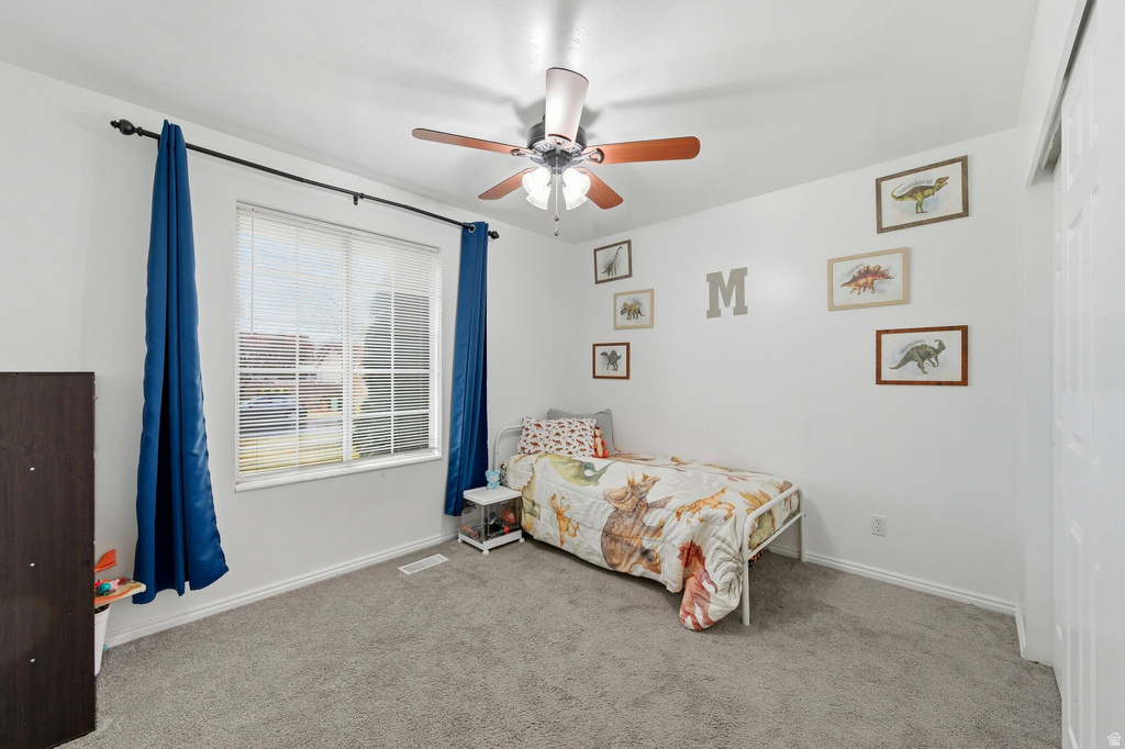 Bedroom with light colored carpet and ceiling fan