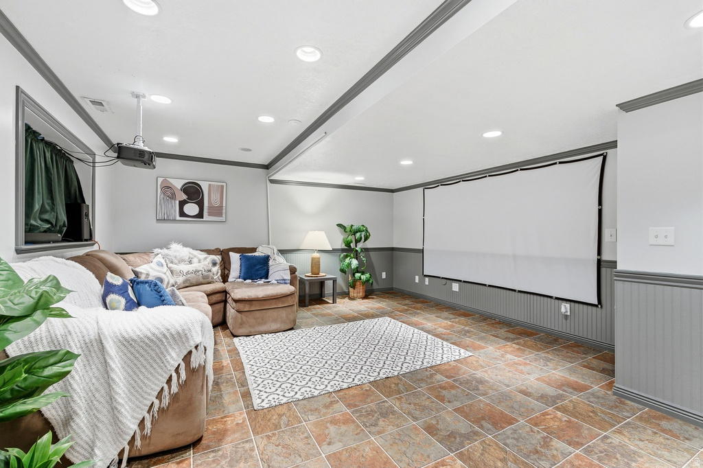 Home theater with wainscoting, crown molding, recessed lighting, and stone finish flooring