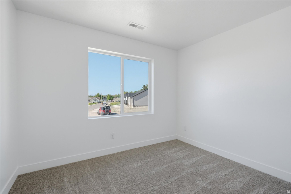 Room featuring neutral carpeting, white walls, white trim, and a double-pane window