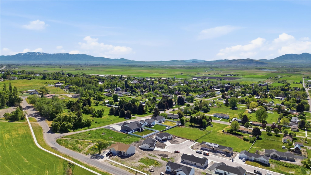 Expansive aerial perspective showcasing a neighborhood with residential development, established homes, and agricultural fields