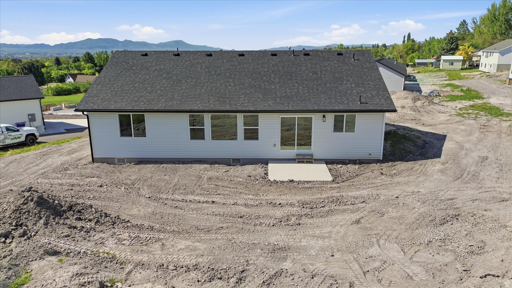 Rear exterior with horizontal vinyl siding and a dark shingle roof