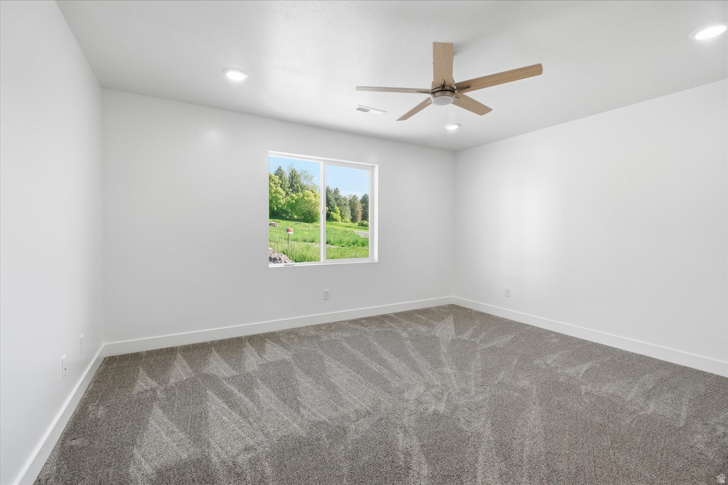 Bright room featuring a large window, recessed lighting, and a ceiling fan