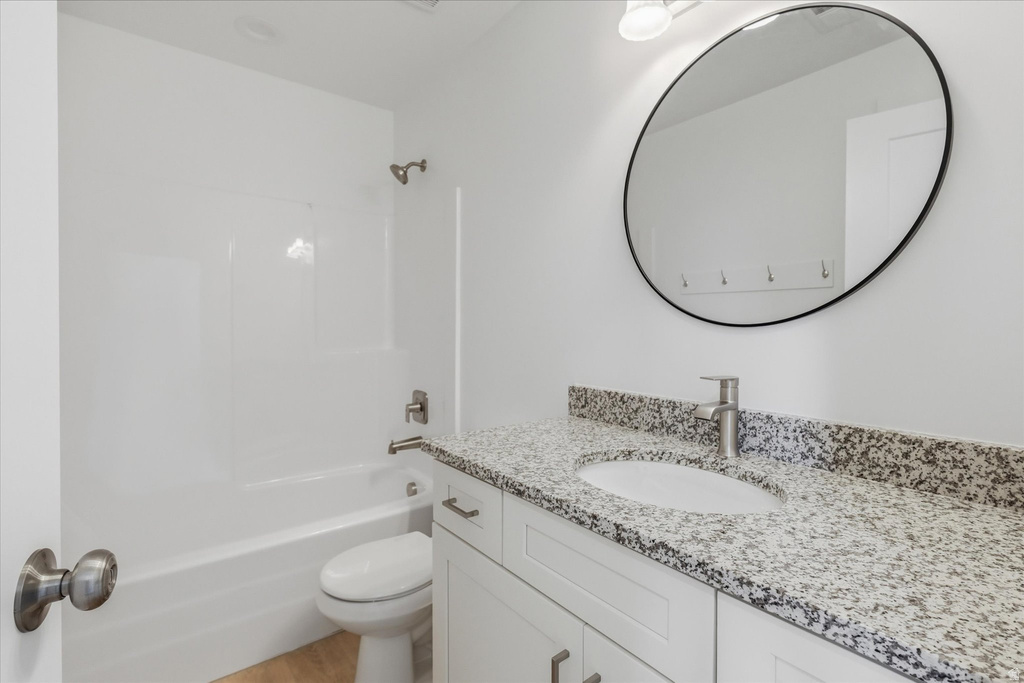 Bathroom featuring a white vanity with granite-finish countertop, undermount sink, and brushed nickel faucet