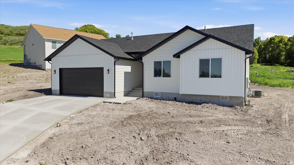 Contemporary single-story residence featuring white vertical siding, a dark asphalt shingle roof, and black trim
