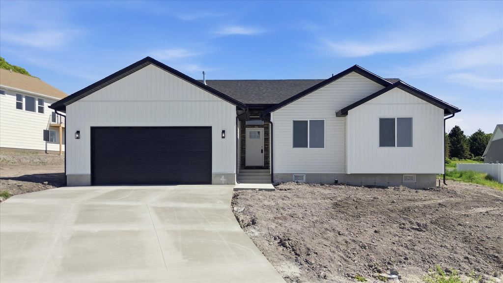 Modern ranch-style residence featuring white siding and black trim