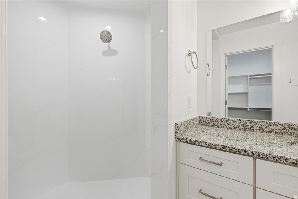 Spacious walk-in shower with a sleek white surround and recessed lighting