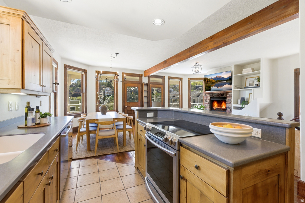 Kitchen featuring light wood cabinetry, stone countertops, and tile flooring