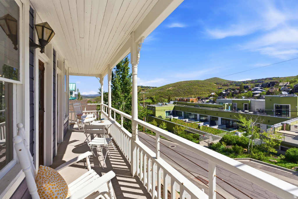 Covered balcony with white wood railing and beadboard ceiling