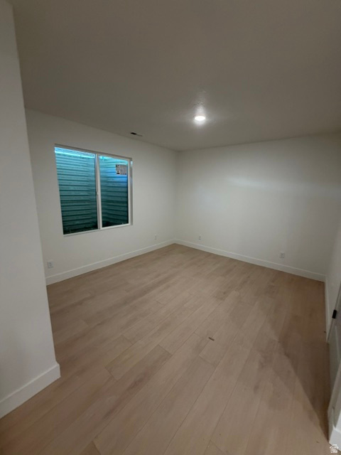 Room featuring light wood-finish flooring, white walls, and a recessed ceiling light