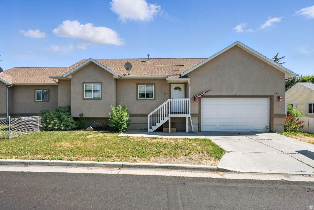 Single story home with stucco siding, driveway, a garage, and roof with shingles