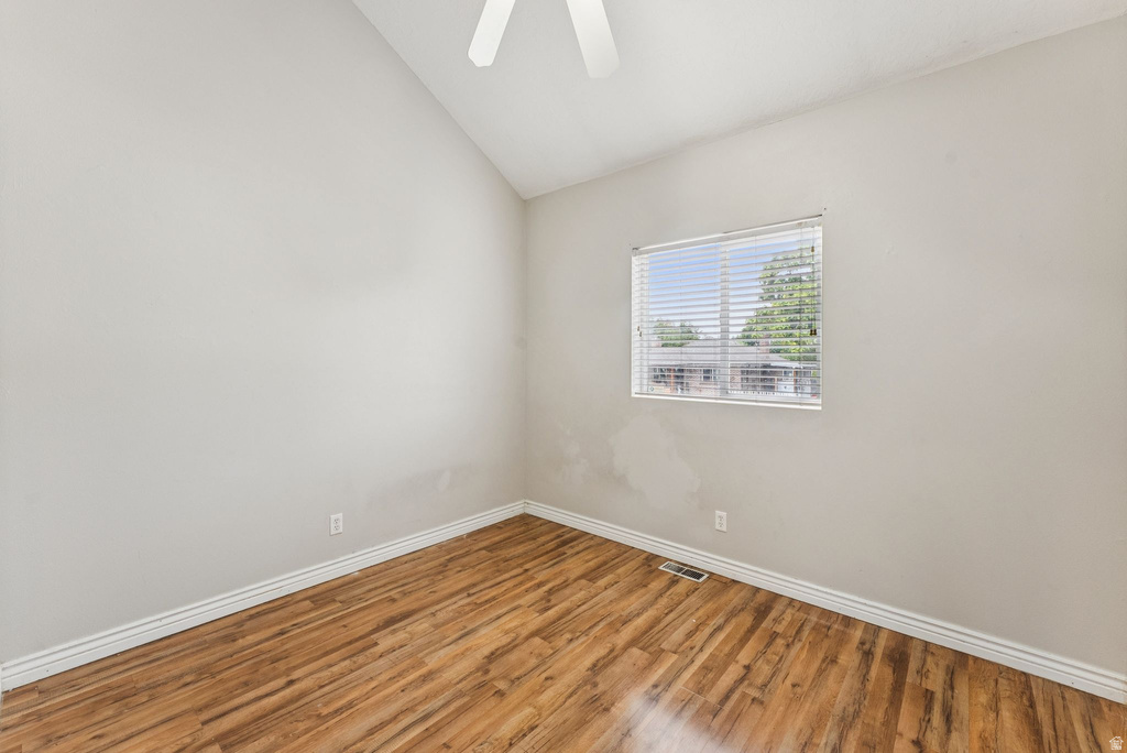 Unfurnished room featuring lofted ceiling, wood finished floors, and ceiling fan