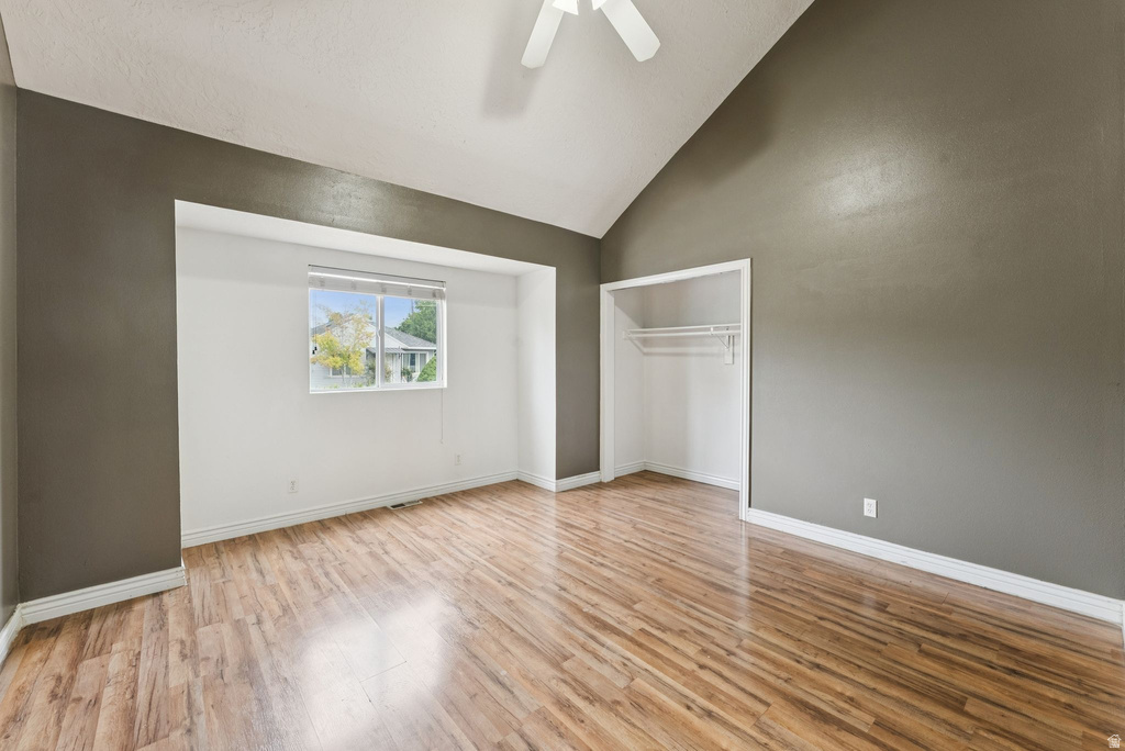 Unfurnished bedroom with vaulted ceiling, light wood finished floors, a ceiling fan, and a closet