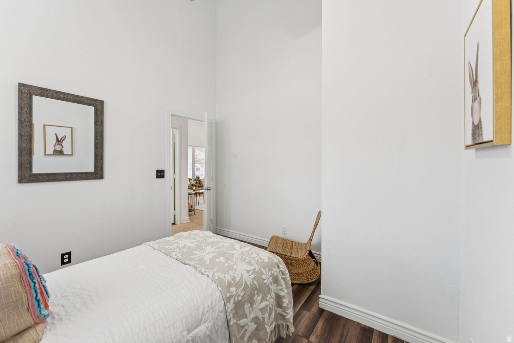 Bedroom with dark wood-type flooring and a high ceiling