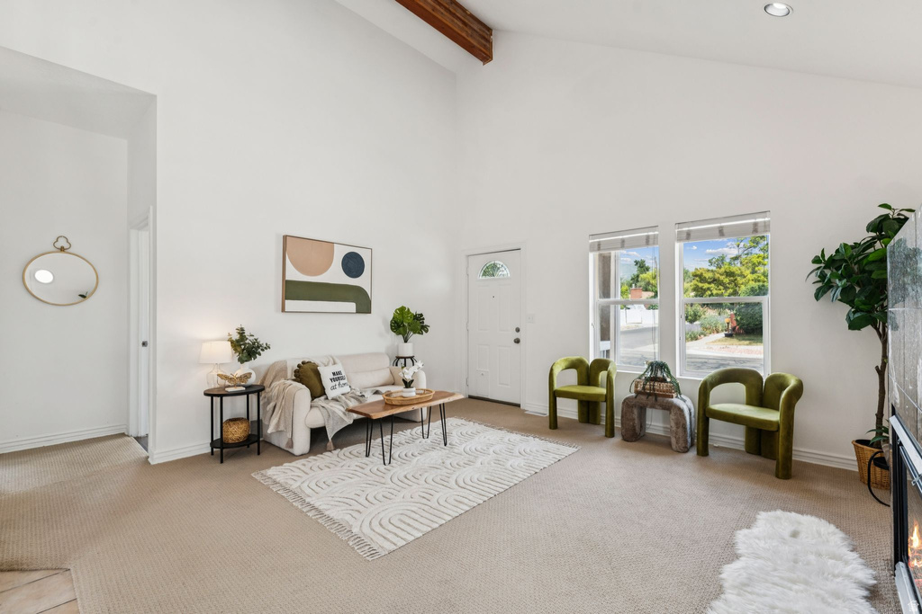 Carpeted living area featuring a warm lit fireplace and lofted ceiling